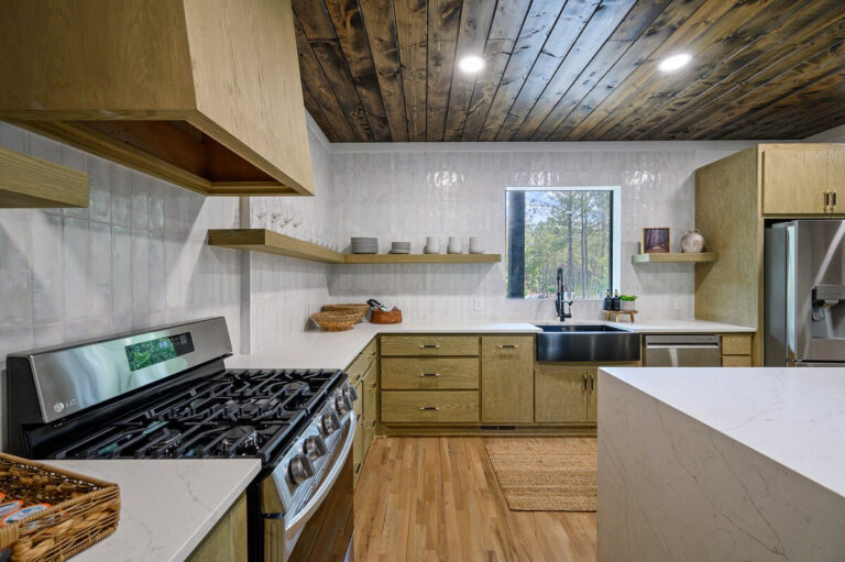 Modern kitchen with stainless steel appliances, wood cabinetry, and granite countertops.
