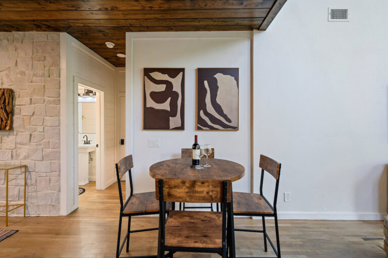 Small secondary dining table with four chairs in a cozy corner of the cabin.
