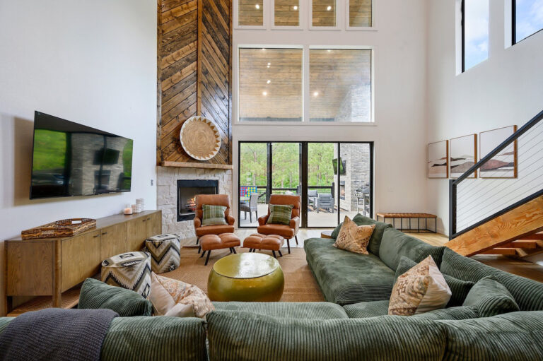 Aquarius luxury cabin rental living room with high ceilings, modern décor, and forest views.