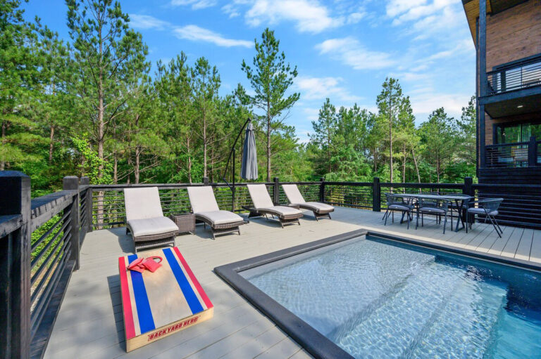 Modern lounge chairs line the pool deck at the Aquarius cabin, offering a comfortable space to relax under the open sky.