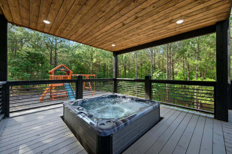 Private hot tub and playset at pet-friendly cabin in Broken Bow