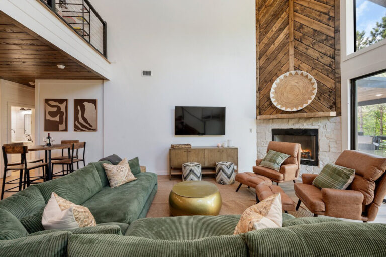 Spacious living room with cozy fireplace, wood-accented walls, and modern furniture.