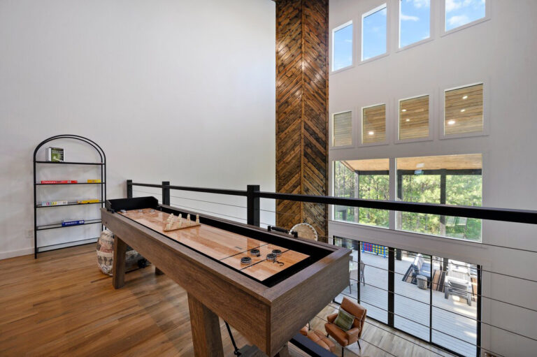 Close-up of a wooden shuffleboard table in the upstairs game area of the Aquarius cabin.