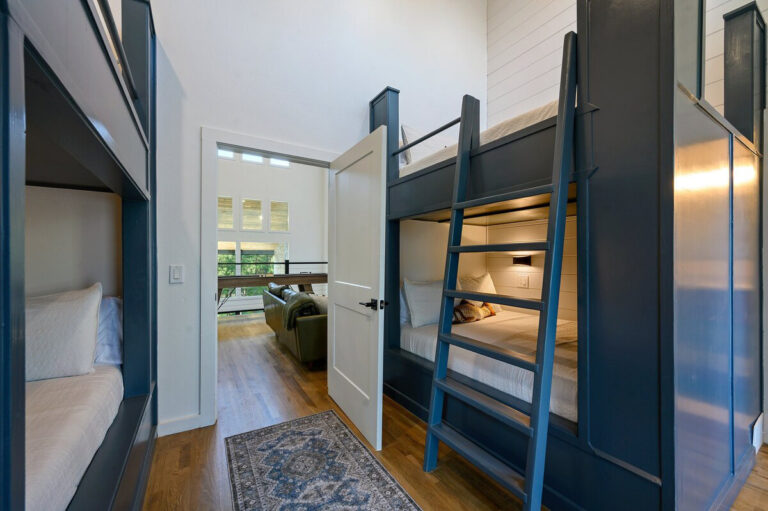 Bedroom featuring dark wooden bunk beds with white bedding and soft lighting.