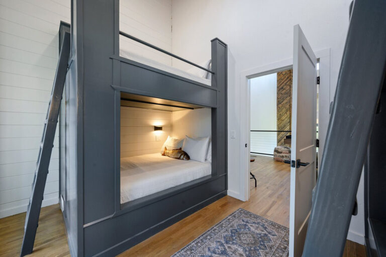 Bunk beds in a warmly decorated room with soft cushions and earth-tone linens.