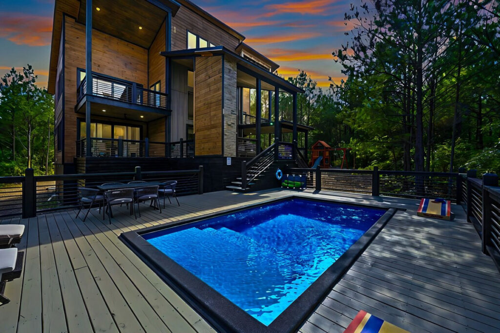 Luxury cabin with a private pool and expansive deck at sunset, perfect for a relaxing getaway.