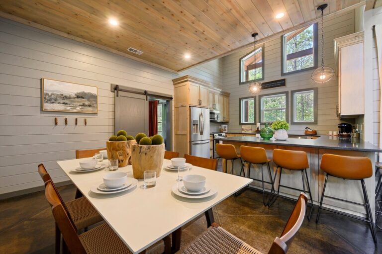 Dining table elegantly set at midnight swim with the open-concept kitchen visible in the background.