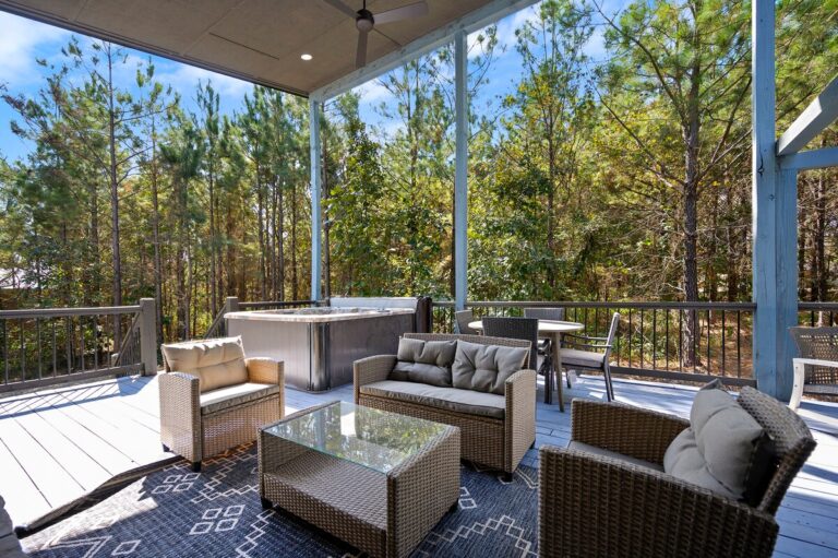 Covered deck with lounge seating and hot tub, ideal for a couple's getaway