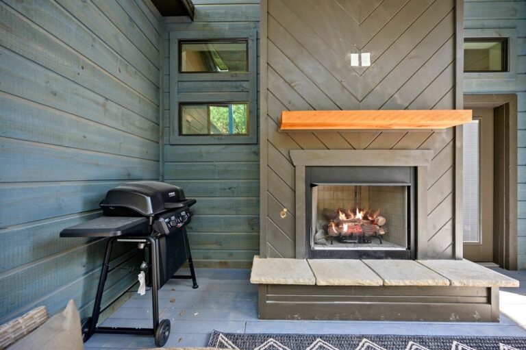Outdoor fireplace and grill on covered deck, ideal for a couple's getaway