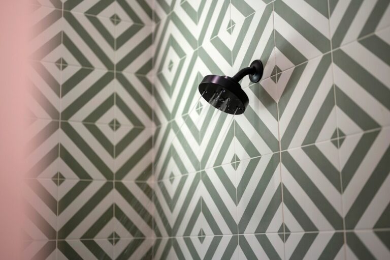 Modern shower with geometric tile and matte black fixture, ideal for a couple's getaway