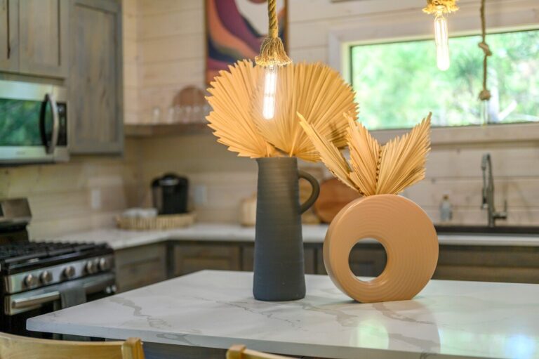 Modern kitchen island with decorative vases and pendant lighting, perfect for a couple's getaway