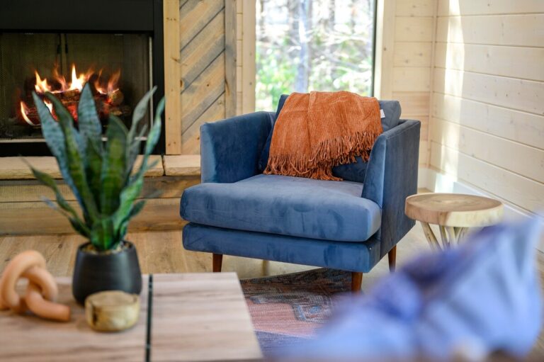 Cozy reading chair by fireplace with throw blanket, ideal for a couple's getaway