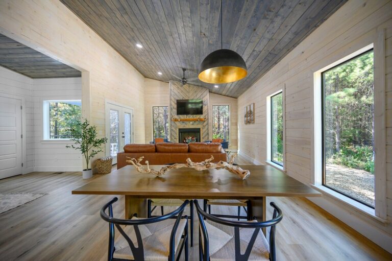 Open-concept dining and living area with forest views, perfect for a couple's getaway