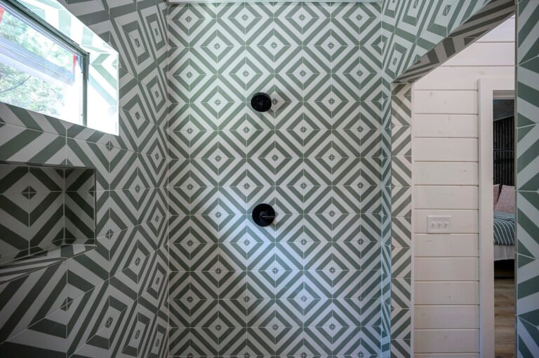 Spacious walk-in shower with bold geometric tile, ideal for a couple's getaway