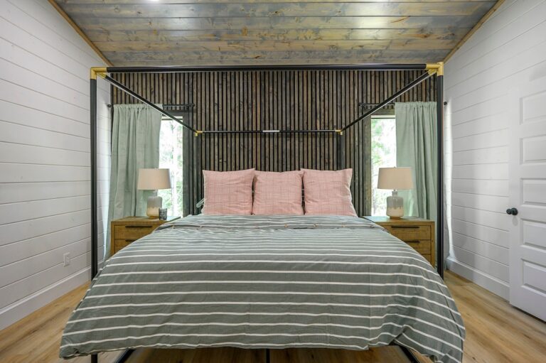 King bedroom with canopy bed, striped bedding, and soft lighting for a couple's getaway
