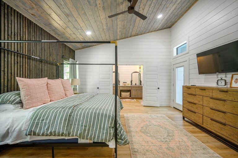 Spacious bedroom with canopy bed, vaulted ceiling, and ensuite bathroom for a couple's getaway