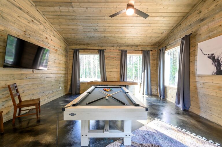 Game room with pool table and large windows for a family reunion retreat.