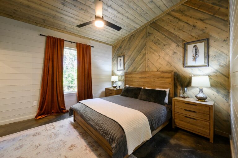 Bedroom with wood accent wall and orange curtains