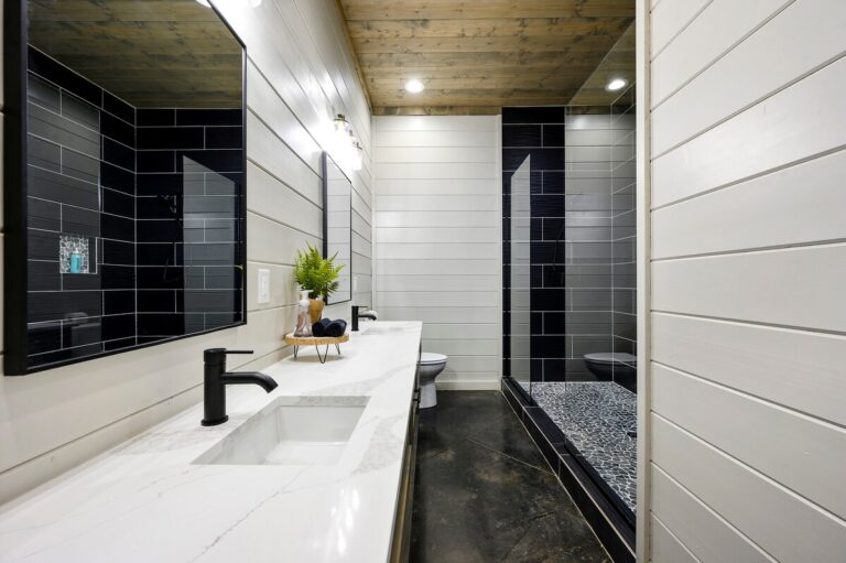 Bathroom with double vanity and black tiled shower