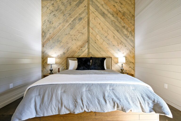 Modern bedroom with wood accent wall and gray bedding