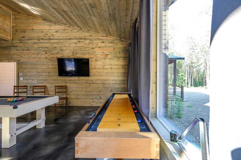 Indoor game room with shuffleboard, pool table, and TV — family reunion entertainment space