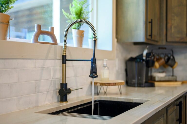 Kitchen sink with running water, farmhouse faucet, and cozy decor — family reunion kitchen prep area