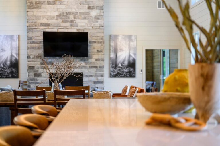 Open-concept living and dining room with stone fireplace and modern rustic decor — family reunion gathering space