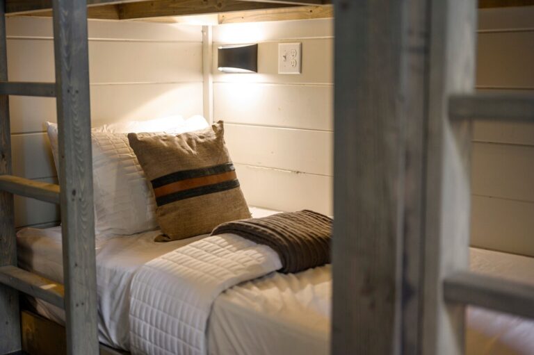 Close-up of cozy bunk bed with soft pillows and reading light — family reunion sleeping space