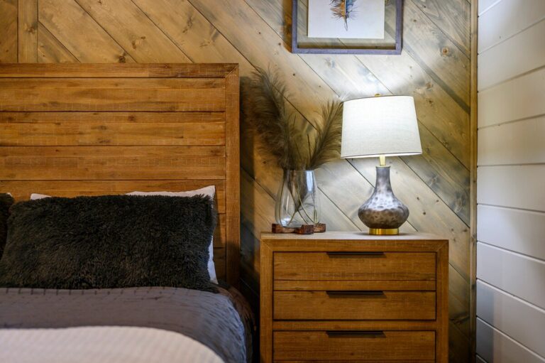Rustic bedroom nightstand with lamp and pampas grass decor — family reunion lodging detail