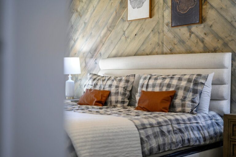 Inviting king bed with plaid linens and modern rustic decor — family reunion accommodation