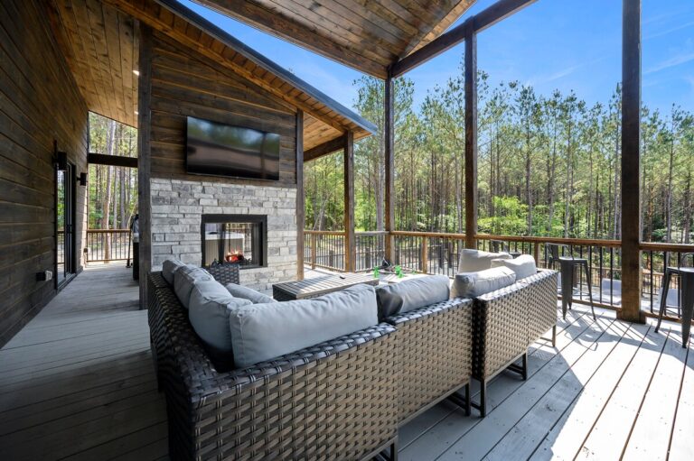 Covered outdoor seating area with fireplace and forest view — ideal for family reunions