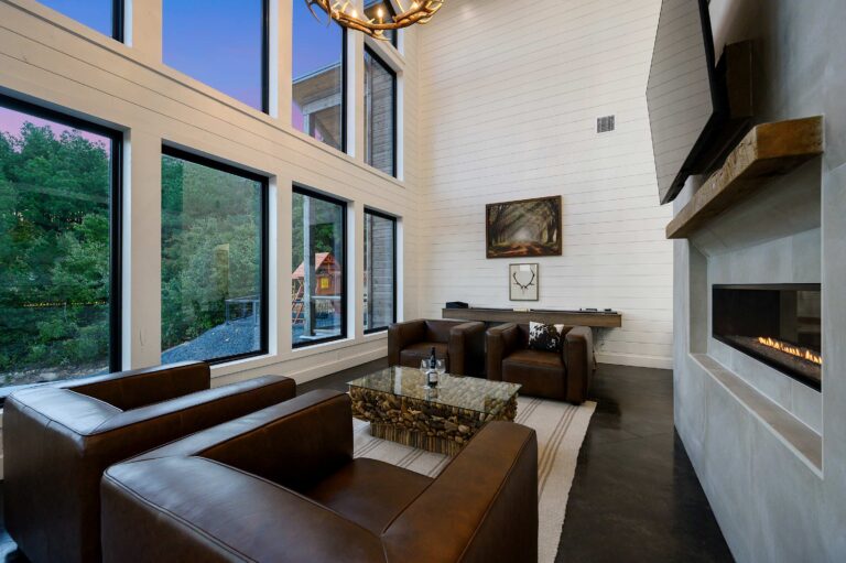 Stylish living room with fireplace and tall windows, ideal for a large family vacation