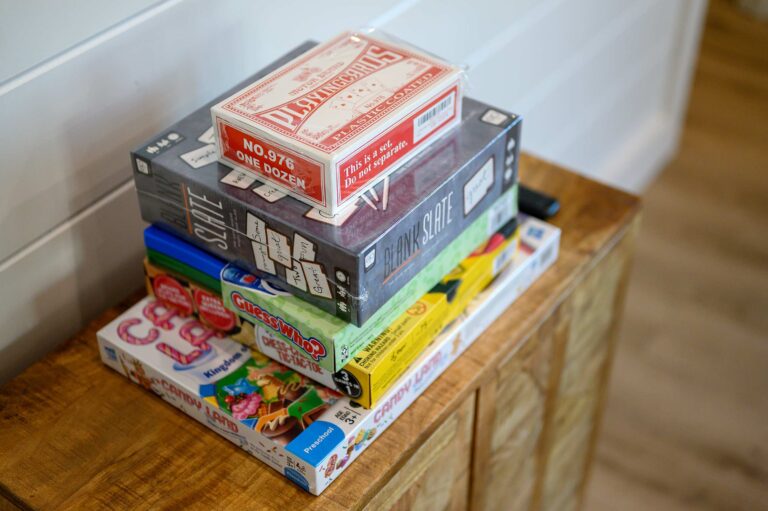 Stack of family board games perfect for large family vacation fun