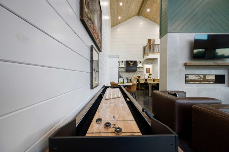 Shuffleboard game in open-concept lodge with kitchen and seating for large family vacation