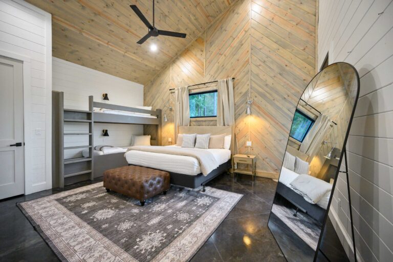 Spacious modern rustic bedroom with king bed and bunk beds for large family vacation