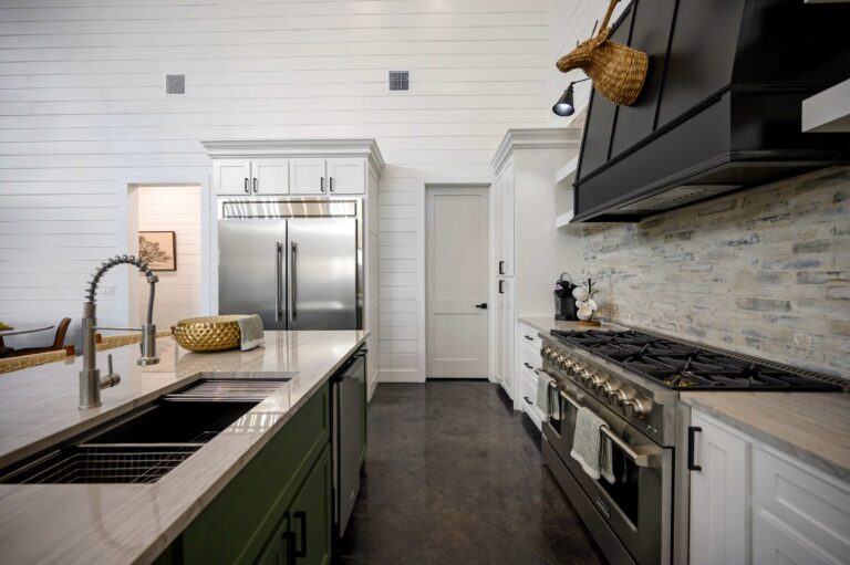 Luxury kitchen with stainless steel appliances, gas range, and marble island