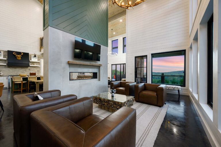 Spacious mountain-view living room with leather chairs and modern fireplace
