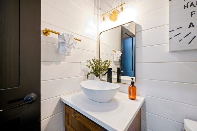 Splish Splash bathroom sink with mirror and plant, perfect for family vacation ideas, refreshing after river activities, and cozy ways to experience nature.