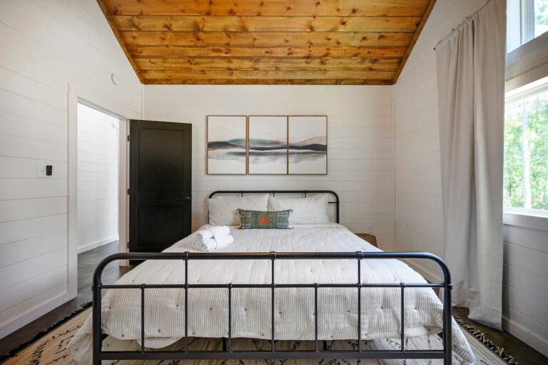 Splish Splash full bedroom with black bedframe, perfect for family vacation ideas, relaxation after river activities, and cozy ways to experience nature.