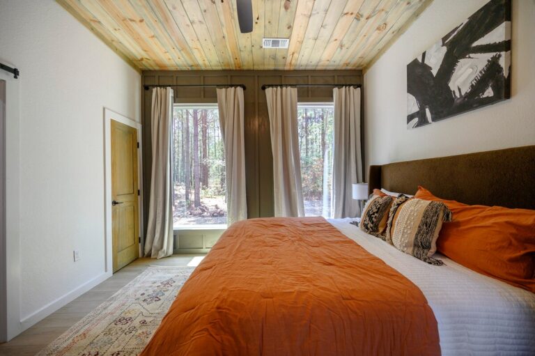 King bedroom with forest view in Sky Dive pet friendly cabin, designed for peaceful nights of stargazing near the outdoor fire pit.