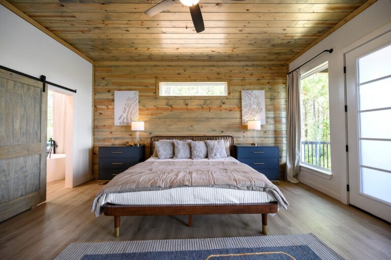 Master bedroom at Sky Dive cabin with wood accent wall, stylish lighting, and cozy bed for stargazing getaways.