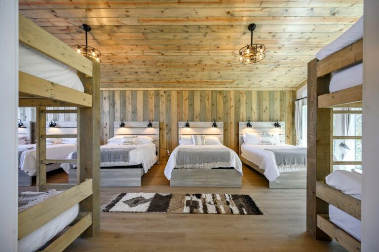 Bunk beds and queen beds in large bunk room at Sky Dive cabin, ideal for stargazing group vacations.