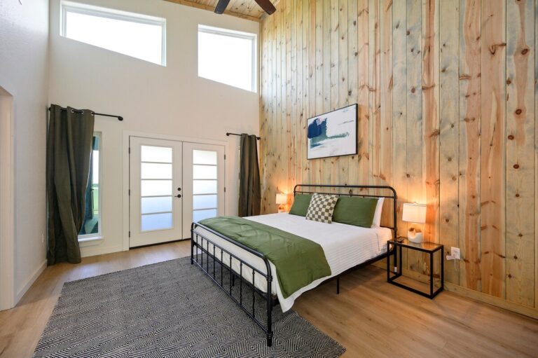 Spacious bedroom with green bedding and tall ceilings for stargazing retreats