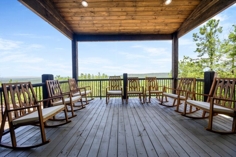 Covered porch with rocking chairs overlooking the forest, ideal for stargazing.