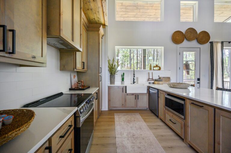 Spacious kitchen with wood cabinets and island inside Sky Dive pet friendly cabin, designed for family meals and evenings of stargazing near the outdoor fire pit.