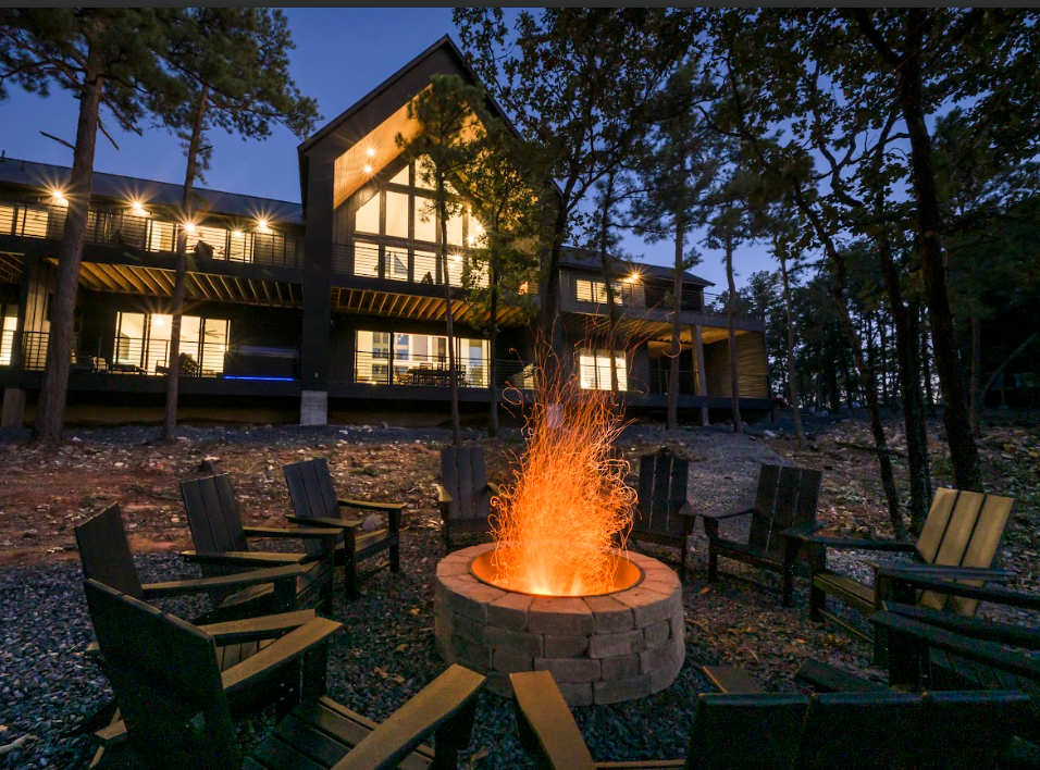 Evening fire pit outside a cabin in beavers bend, showcasing a cozy cabin in beavers bend surrounded by forest at night.