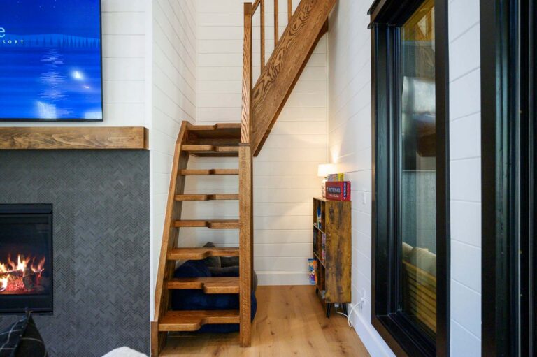 Loft game area inside Blue Note Broken Bow cabin with rustic staircase and family entertainment space near river activities.