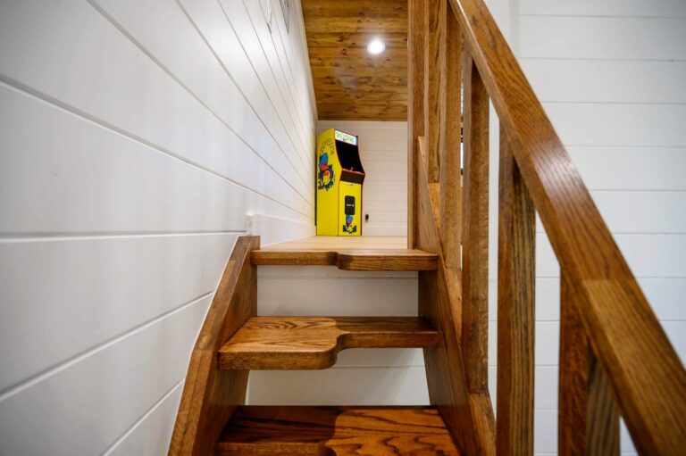 Rustic wood staircase leading to loft area inside Blue Note Broken Bow cabin near outdoor fire pit and family river activities.