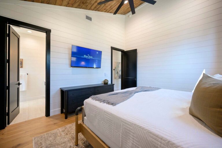Luxury primary bedroom suite at Blue Note Broken Bow cabin with vaulted wood ceilings, king bed, and easy access to river activities near Mountain Fork River.