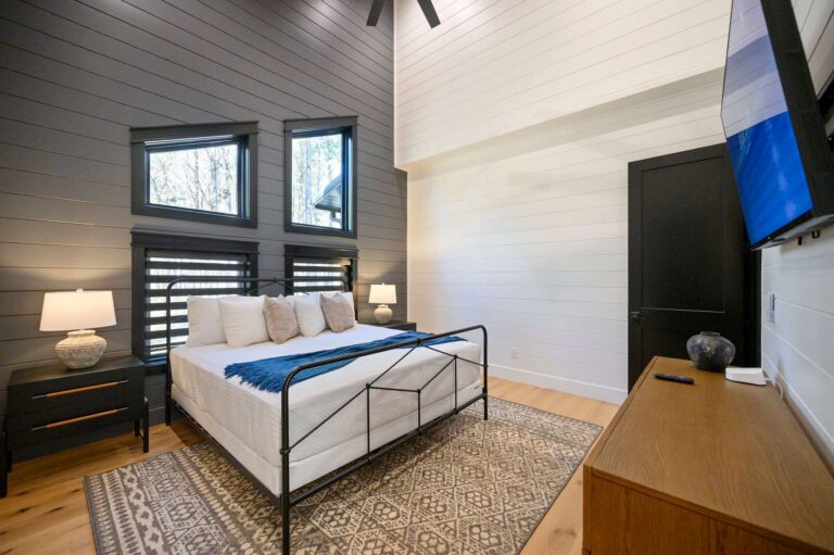 Elegant luxury bedroom at Blue Note Broken Bow cabin with modern furnishings, vaulted ceilings, and relaxing cabin atmosphere near river activities.